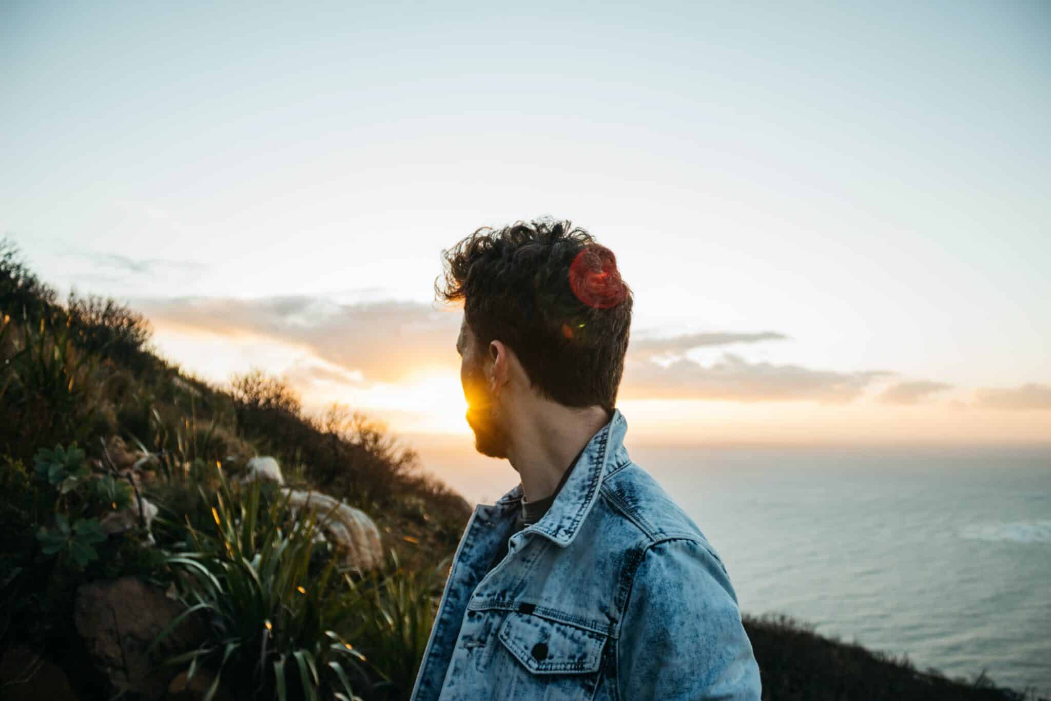 Man looking at sunset | Photo by Jonny Hayes on Unsplash