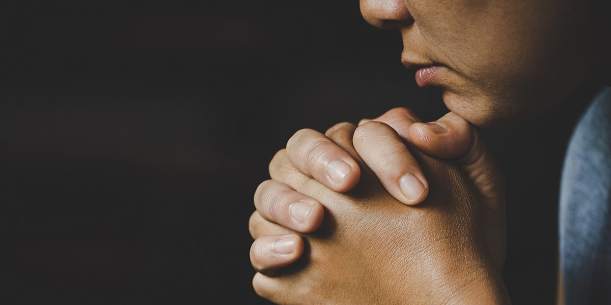 woman praying with folded hands